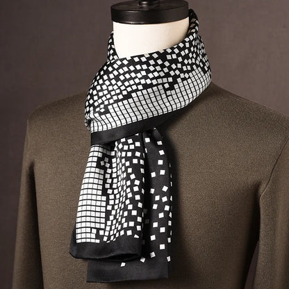 Black and white silk scarf with a scattered square mosaic pattern and black edging, on a mannequin in an olive jumper. 13