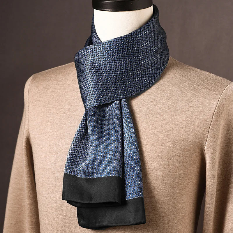Blue silk scarf with a small woven basket-weave pattern and black ends, draped around a mannequin in a beige jumper. 3