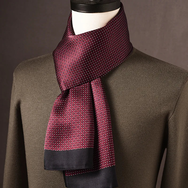 Burgundy silk scarf with a woven-look pattern, tiny white dots and navy ends, styled on a mannequin with an olive jumper. 6