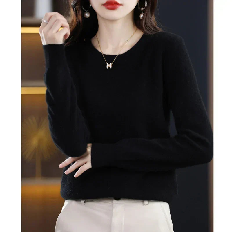 Black round-neck jumper with a fluffy finish, worn with cream trousers and hands resting at the waist 19