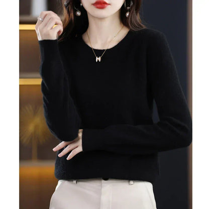 Black round-neck jumper with a fluffy finish, worn with cream trousers and hands resting at the waist 19