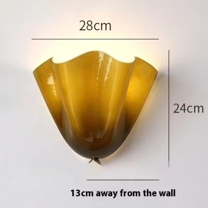 Lit amber-olive glass sconce with dimension lines showing width, height and projection from the wall. 14