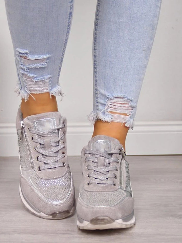 Front view of grey lace-up trainers with sparkly toe panels and side zips, worn with ripped jeans 6
