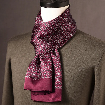 Burgundy silk scarf with a small white and dark leaf-like pattern and plain burgundy ends, draped on a mannequin in an olive jumper. 17