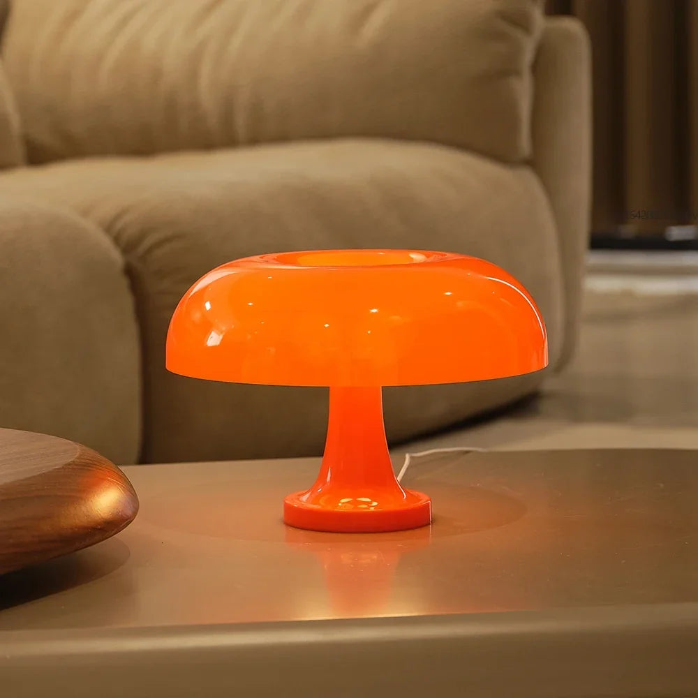 Orange lamp switched on and standing on a coffee table in front of a beige sofa, its white cable trailing behind. 5