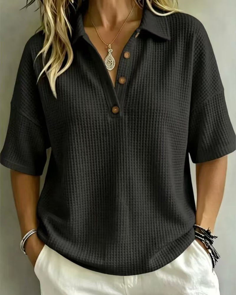 Model wearing the black waffle knit polo top, showing the button placket and relaxed short sleeves 5