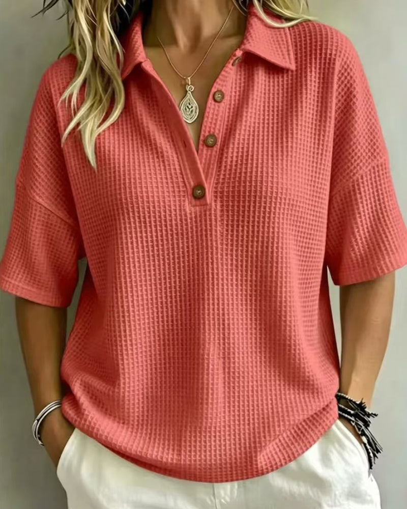 Front view of the coral waffle knit polo top, worn open at the neck with brown buttons 4