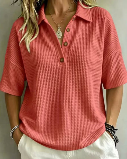 Front view of the coral waffle knit polo top, worn open at the neck with brown buttons 4