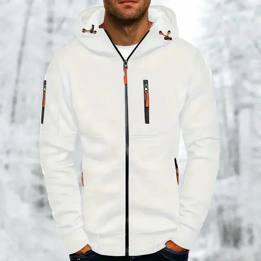Model wearing the hoodie in white with orange zip pulls and a black front zip, hands in pockets, snowy backdrop. 3