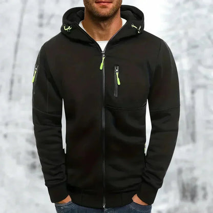 Model wearing the hoodie in black with lime green zip pulls, showing chest and sleeve zip pockets against a snowy backdrop. 7