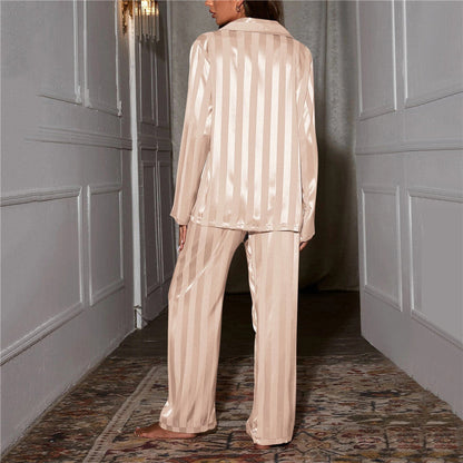 Back view of the champagne-coloured striped satin pyjama shirt and wide-leg trousers worn in a hallway 2