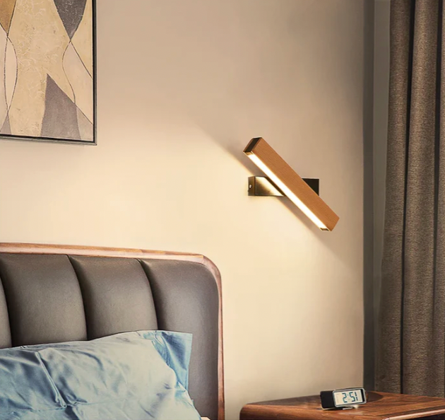 Rotated wooden light with a black base above a bedside table with a digital clock, beside curtains. 8