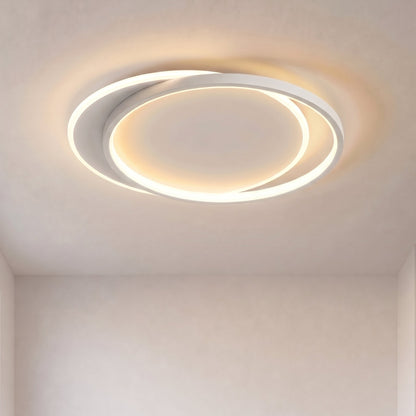 Two overlapping white rings glowing warmly on a plain ceiling, seen from below 1