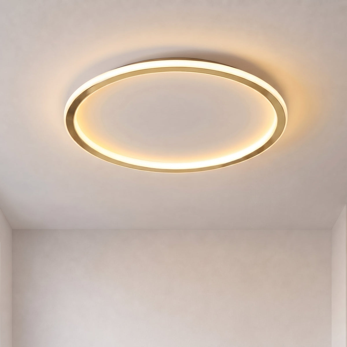 Lit gold ring ceiling light glowing warmly against a plain pale ceiling, seen from below 1