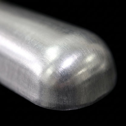 Close-up of the rounded tip of the scoop, showing its brushed, lightly scratched metal surface against a black background. 3
