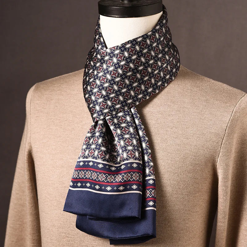 Navy silk scarf with a small star and oval motif and a diamond-patterned red and white border, draped on a mannequin in a beige jumper. 21