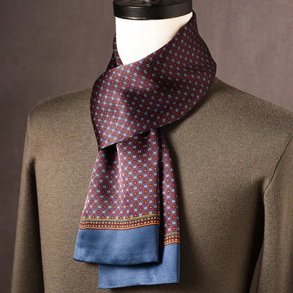 Silk scarf with small red and blue circular motifs on plum, wide blue border, draped on a mannequin with olive jumper. 1