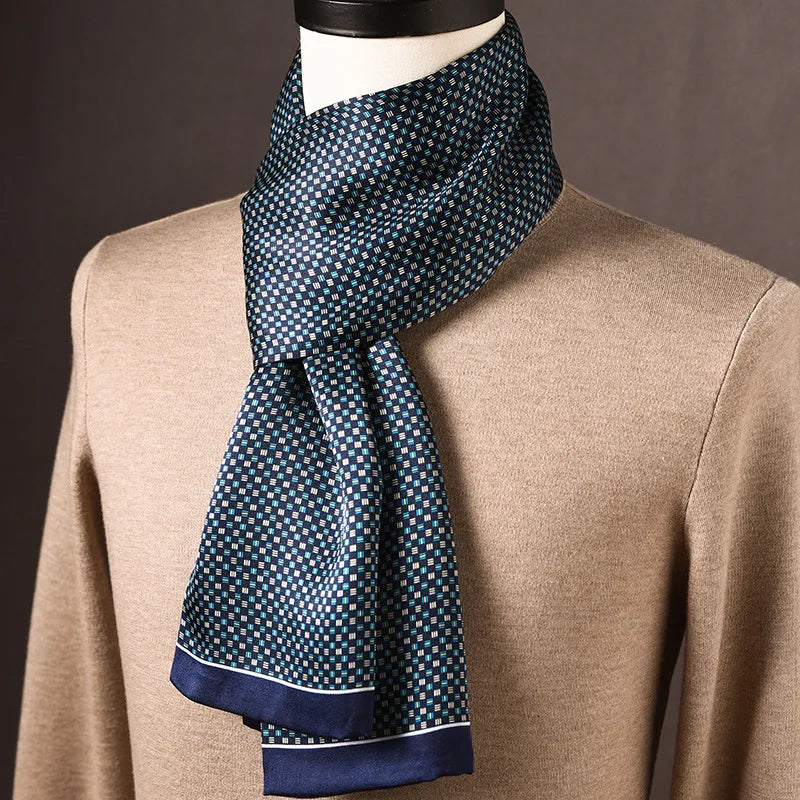 Navy silk scarf with a small teal and white check pattern and a navy border, draped on a mannequin in a beige jumper. 24