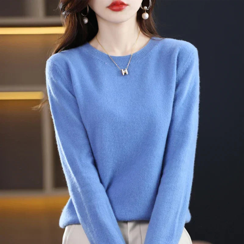 Model wears the round-neck jumper in bright sky blue with cream trousers and pearl earrings 22