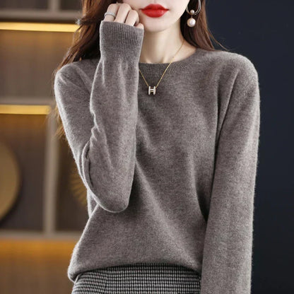 Model wears the round-neck jumper in taupe-grey with a houndstooth skirt and gold pendant necklace 21
