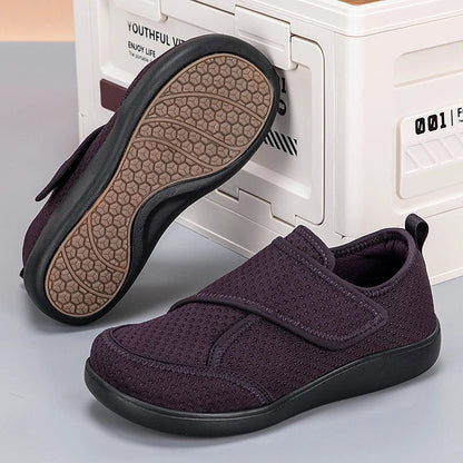 Dark purple mesh shoe with black sole beside its pair, showing the honeycomb-patterned tread underneath 4