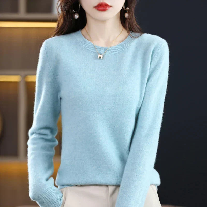 Model wearing a soft sky-blue crew-neck jumper with cream trousers, one hand in pocket 11