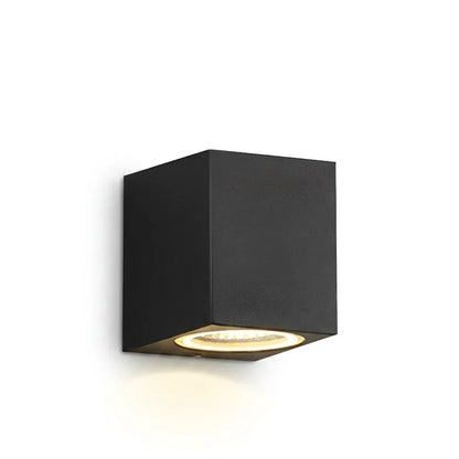 Black square single-light wall lamp glowing warmly downward, shown against a plain white background 1