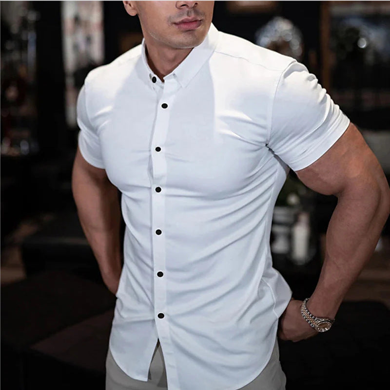 White short sleeve shirt with dark buttons, worn by a model with one hand in his pocket and a metal watch. 2
