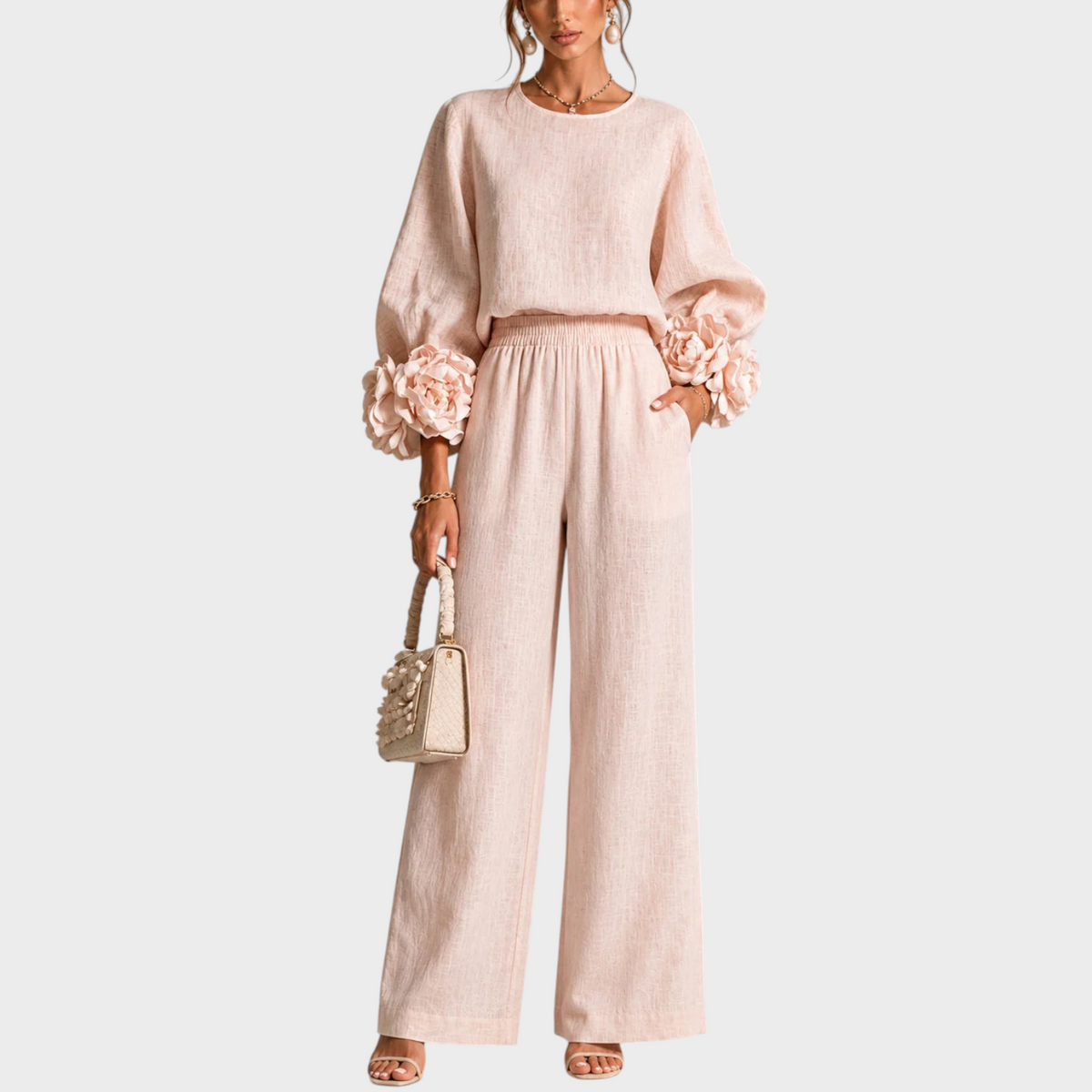 Model in the blush pink set, front view, hand in pocket, holding a cream bag 1