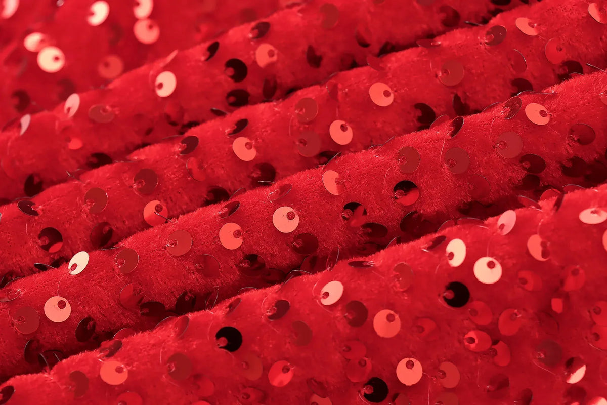 Extreme close-up of the red sequins stitched onto soft, plush ribbed velvet fabric 10