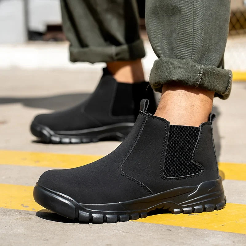 Model wearing black elastic-sided ankle boots with chunky treaded soles on a yellow-striped pavement 1
