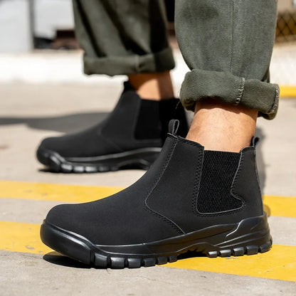 Model wearing black elastic-sided ankle boots with chunky treaded soles on a yellow-striped pavement 1