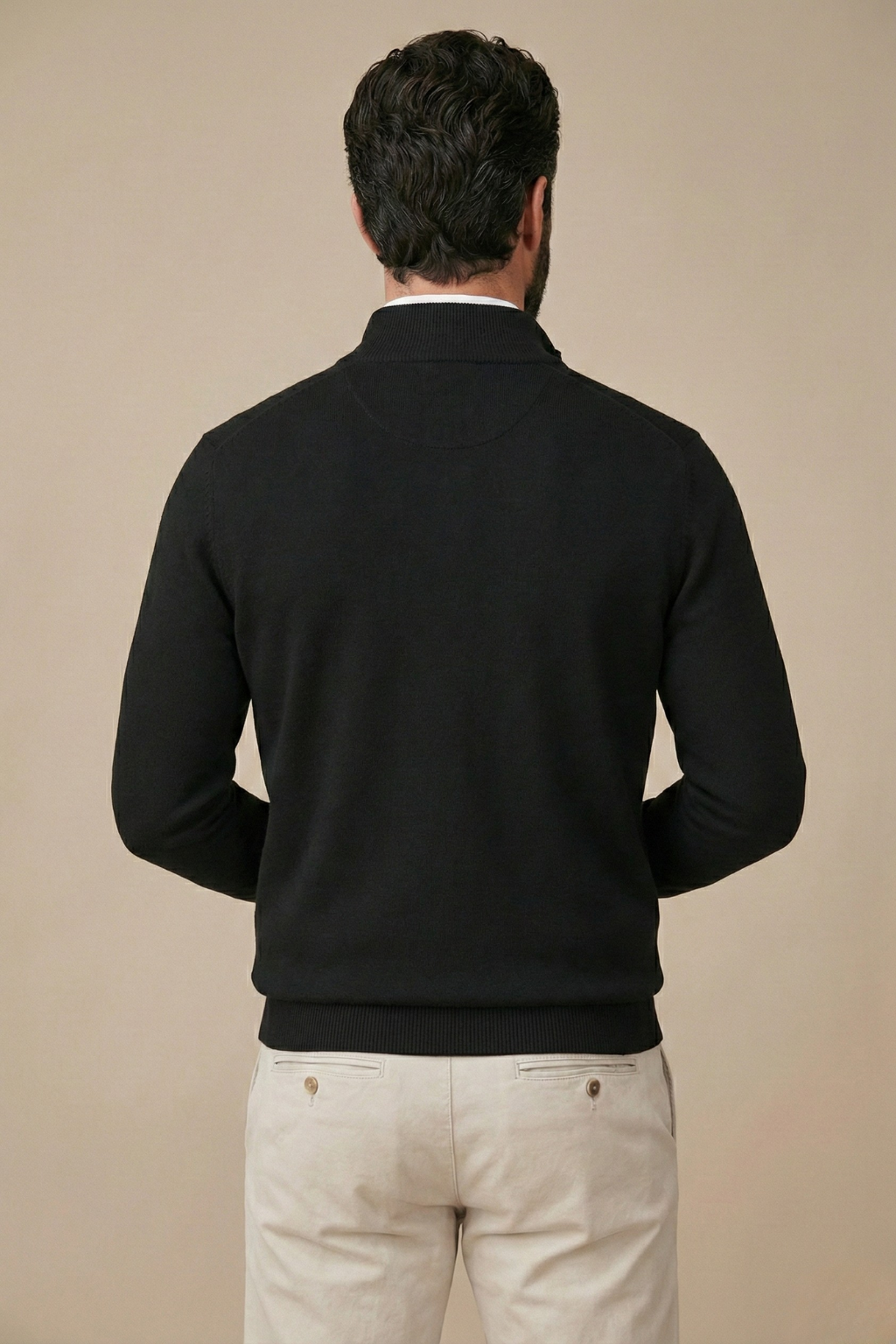 Back view of the black half-zip jumper on a model, showing the ribbed hem and stand collar 2