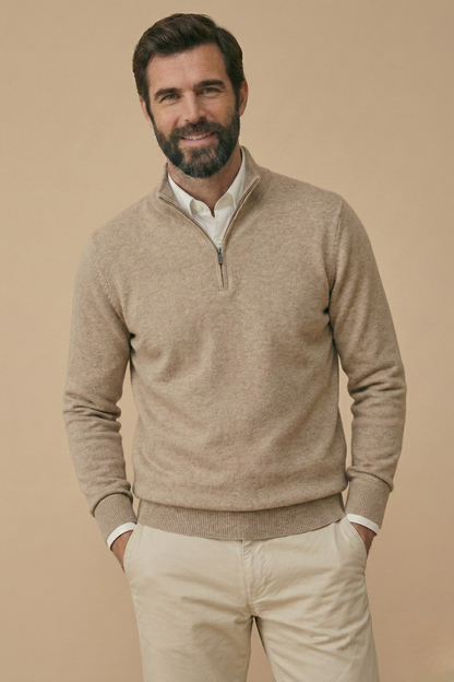 Smiling model wears the oatmeal-beige half-zip jumper over a white shirt, hands in trouser pockets 6