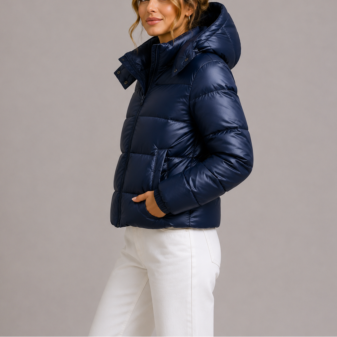 Side view of a model in the navy glossy puffer jacket, hand in pocket, hood down 1