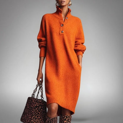 Model wearing the orange knitted dress with a leopard-print handbag and boots, hand in pocket 1