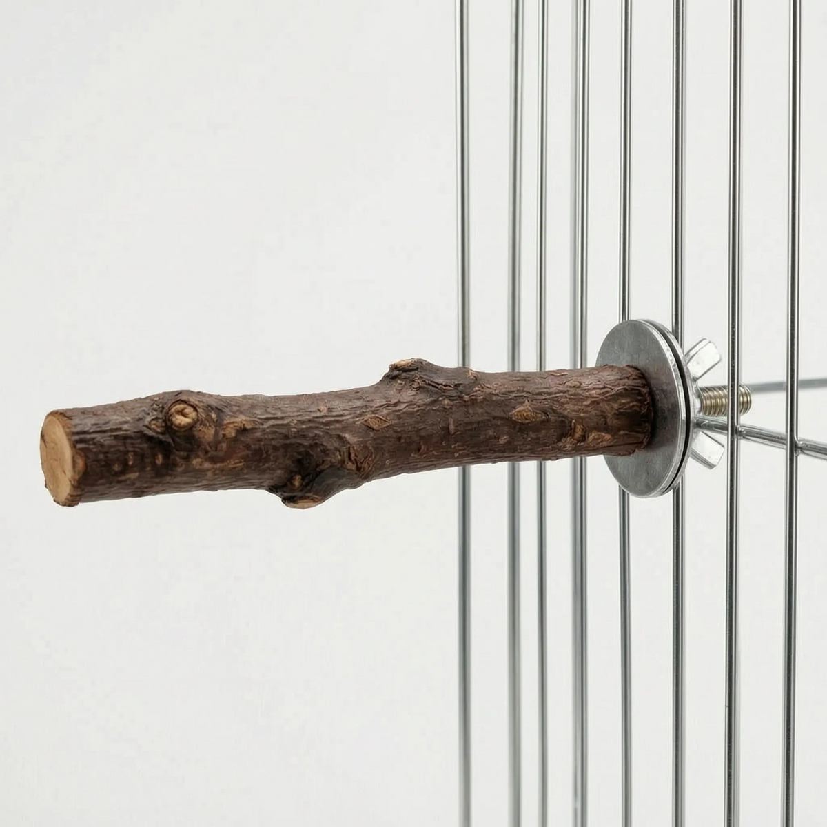 Side view of the bark-covered perch attached to cage wires, showing the cut end and the metal bolt fitting. 5