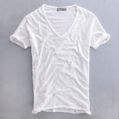 White version of the V-neck t-shirt laid flat, with a slightly sheer textured weave, raw-edged neckline and rolled sleeve cuffs. 2