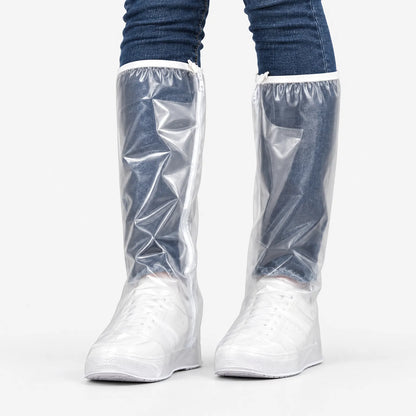 Front view of tall clear overshoes with a white zip and elasticated top edge, worn over white trainers and blue jeans. 2