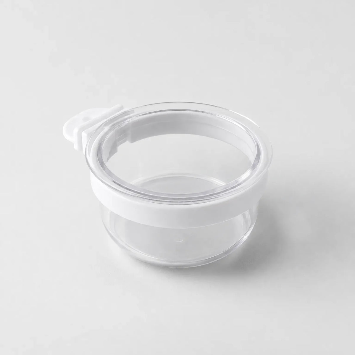 Empty clear round cup with a white band around the rim and a small white hook tab, shown on a plain light background. 1