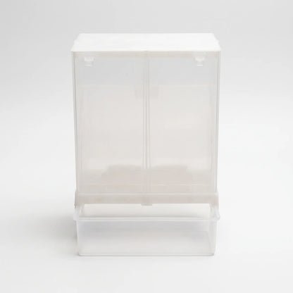 Front view of the clear plastic seed dispenser with a white lid and an attached catch tray at the bottom. 1