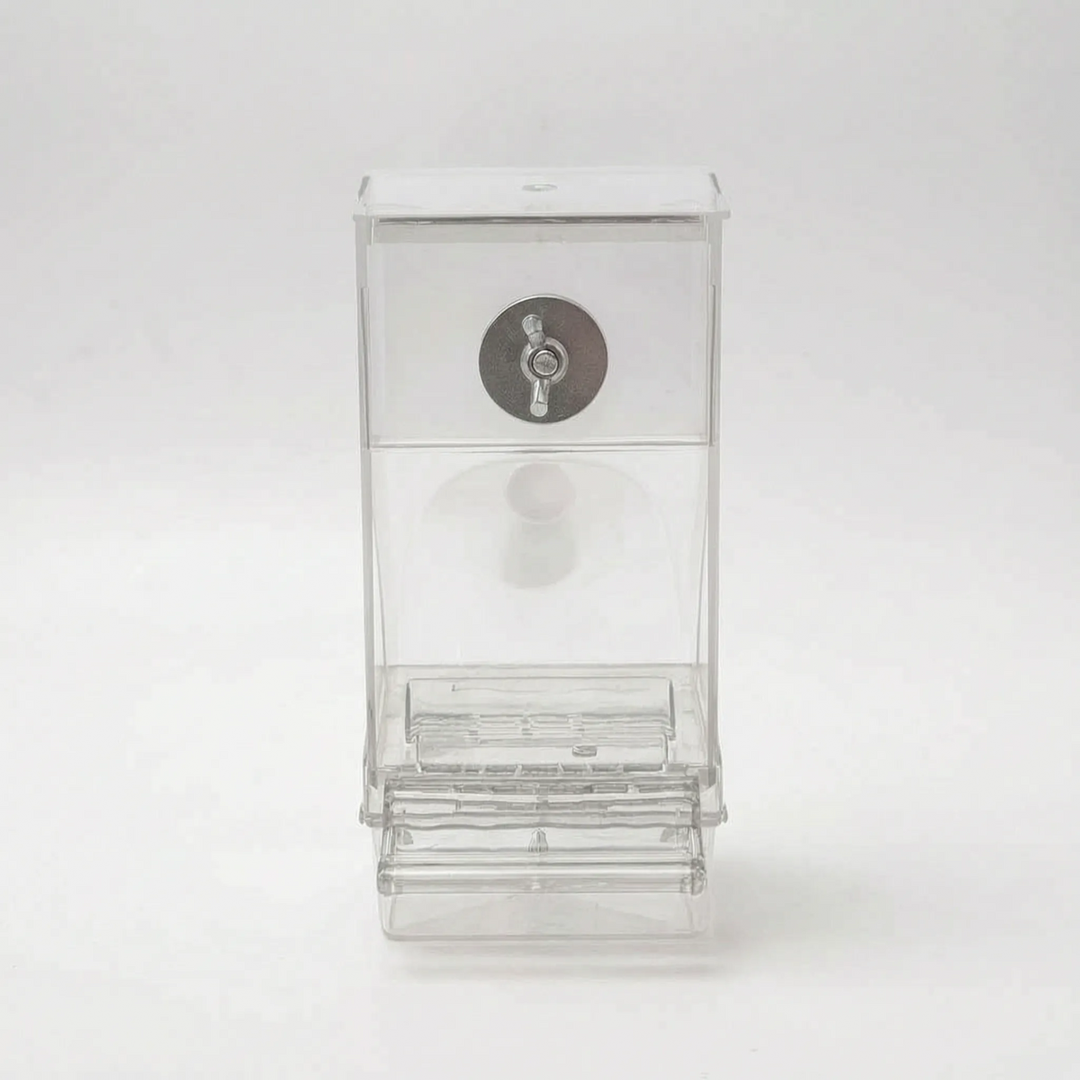 Empty clear feeder on a plain background, front view, showing the lid, metal wing-nut fixing and the ridged feeding tray at the bottom. 5