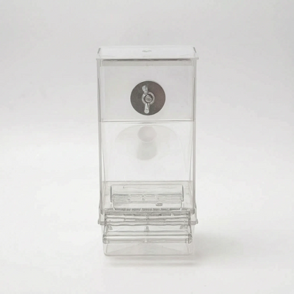 Empty clear feeder on a plain background, front view, showing the lid, metal wing-nut fixing and the ridged feeding tray at the bottom. 5