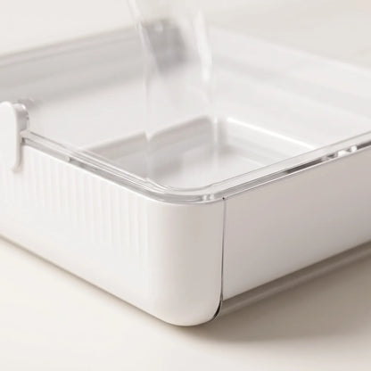 Close-up of the white ribbed tray corner with its clear rim and latch, showing the shallow water compartment inside. 3