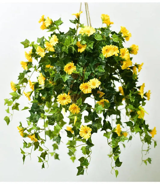 Yellow artificial flowers with dense green leaves cascading from a hanging basket, suspended by rope against a plain white background. 2