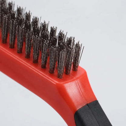 Close-up of the red wire brush head, showing its dense tufts of stiff metal bristles and the black grip. 3