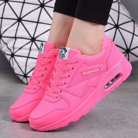 Bright neon pink trainers with air-cushion soles, worn with black leggings against a geometric cushion 3