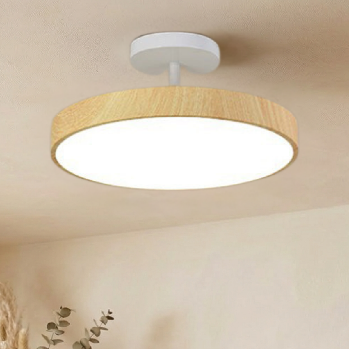 Light oak-effect round light with a white canopy and stem, shining a bright white glow from a cream ceiling. 4