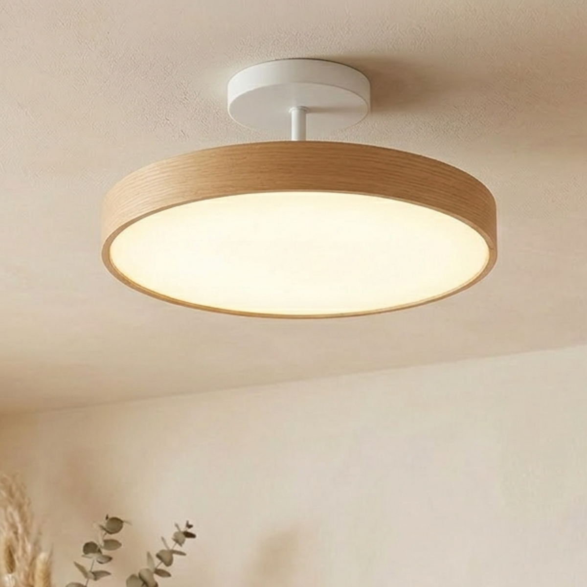 Pale oak-effect round light with a white canopy and stem, giving a soft warm glow on a cream ceiling. 5