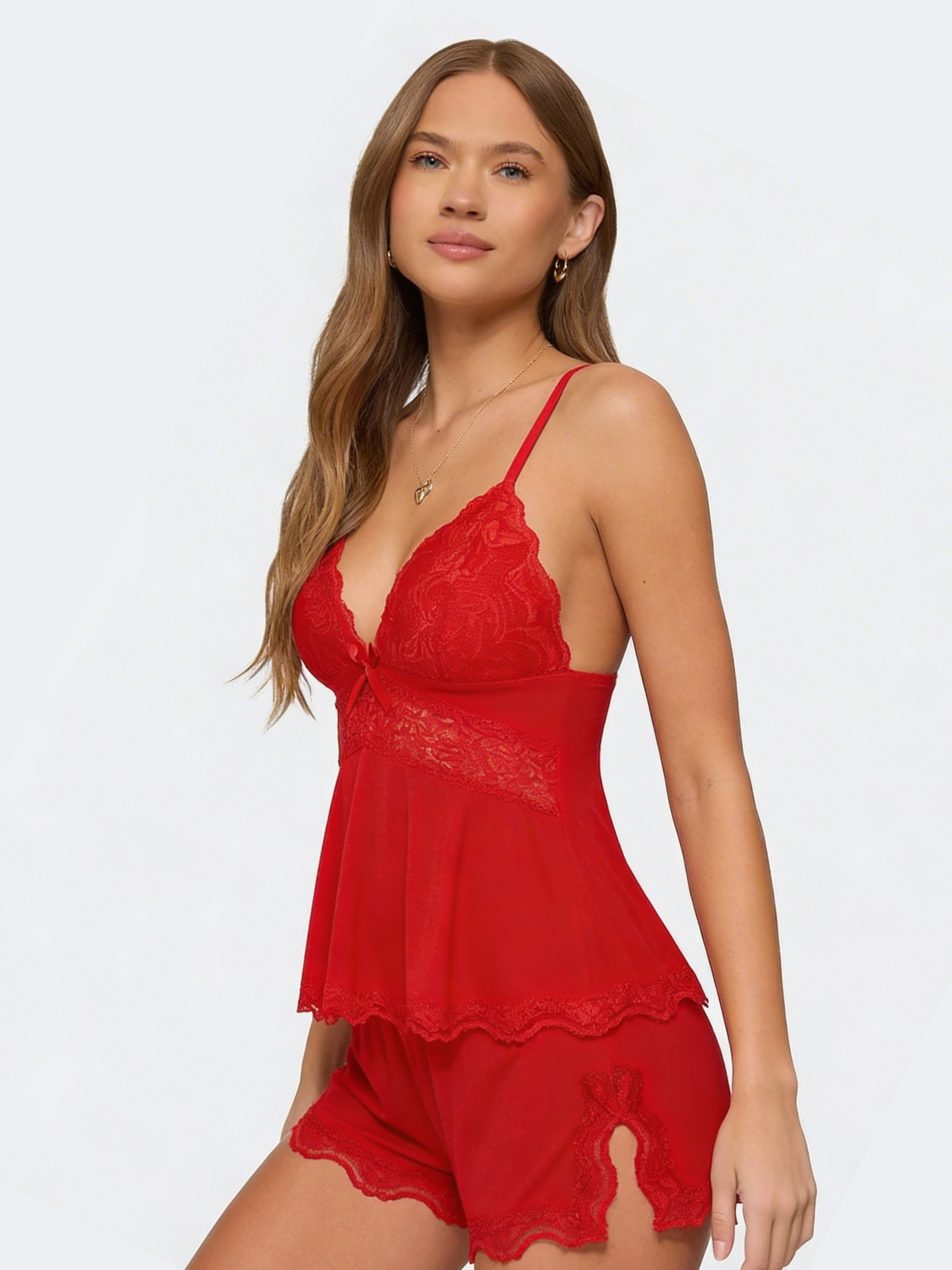 Model turned three-quarters in the red set, showing the lace side slit on the shorts 22